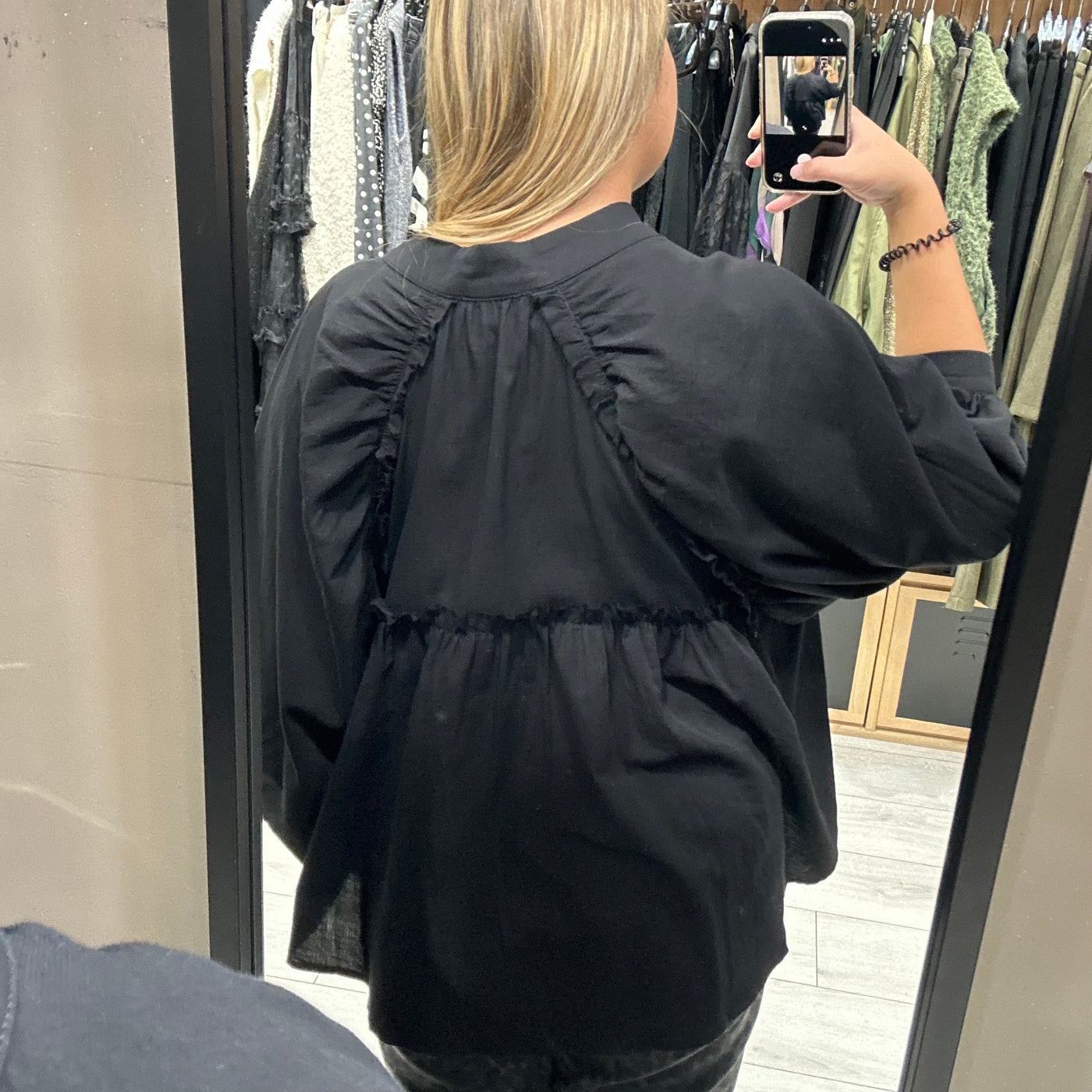 Blouse noire plus longues sur le derrière avec manches bouffantes et boutons