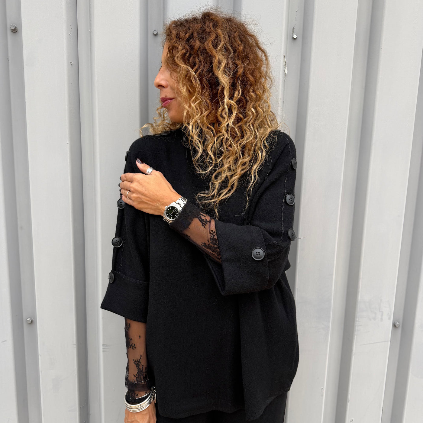 Pull en maille noir avec détails de boutons le long des manches 