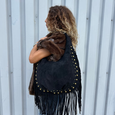 Sac à main hobo noir clouté dorés avec des franges, porté épaules ou en bandoulière 